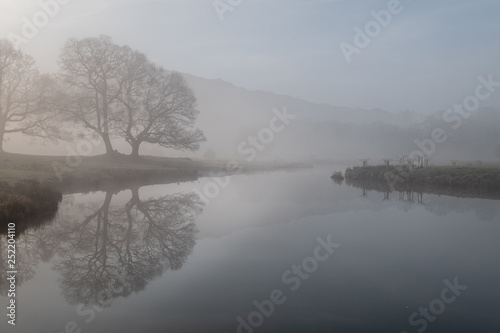 Early morning mist hanging over the River Brathay between Elterwater and Skelwith Bridge, Lake District, UK