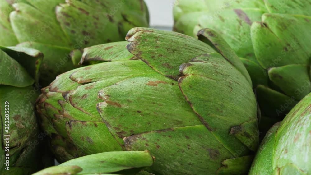 Whole fresh artichokes on plate, rotating Whole fresh artichokes on plate, rotating