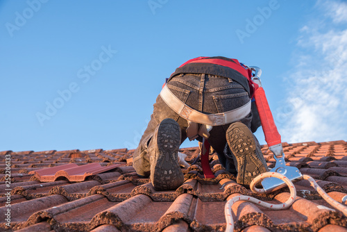 Arbeiter am Dach beim Austausch defekter Dachziegel photo