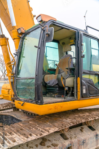 The cab and dirty grousers of a yellow excavator