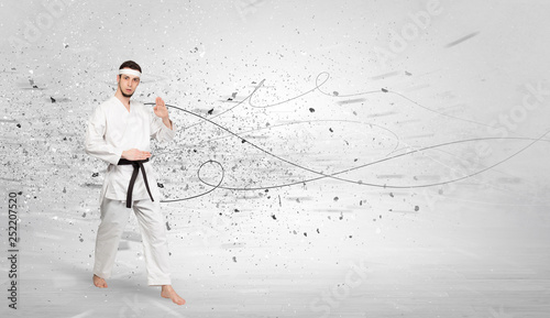 Young karate trainer doing karate tricks with chaotic concept 