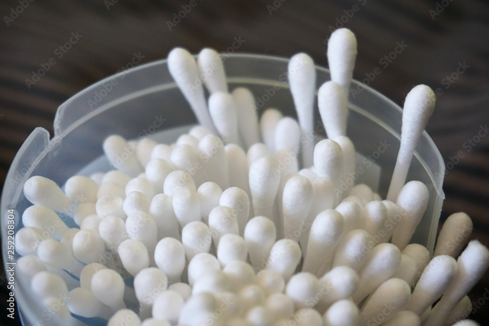 Cotton buds white in a box plastic stick close up in transparent jar medical for makeup and health personal hygiene 