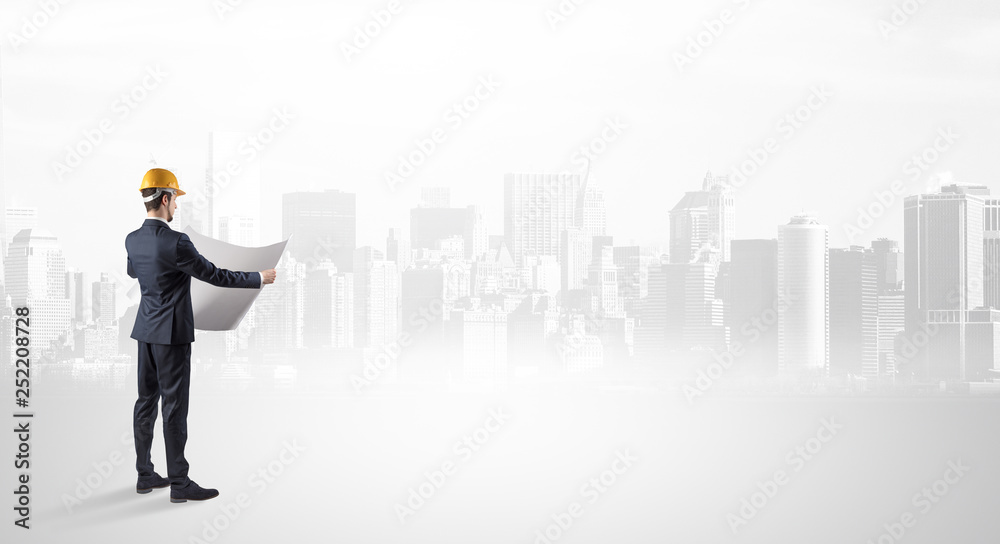 Young supervisor architect standing and looking at a big city panorama
Young supervisor architect standing and looking at a big city panorama