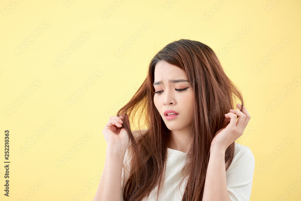 Young asian woman brushing her hair and disappointing condition her hair Young asian woman brushing her hair and disappointing condition her hair