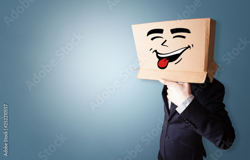 Young boy standing and gesturing with a cardboard box on his head 