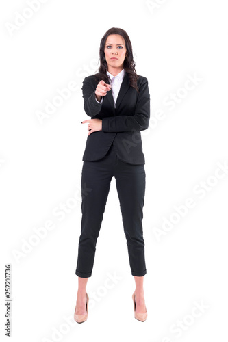 Authoritative business woman in formal suit pointing finger and showing at you. Full body isolated on white background. 