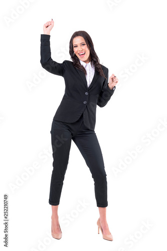 Excited joyful business woman in formal clothes dancing and celebrating looking at camera. Full body isolated on white background. 