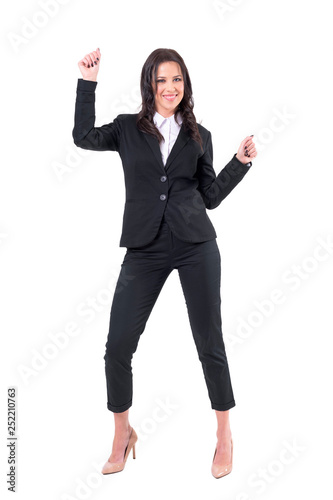 Happy relaxed business woman in formal suit dancing celebrating success. with clenched fists. Full body isolated on white background. 