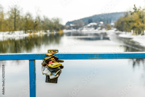 Colored locks on the bridge over the river. Colored metal locks for love forever