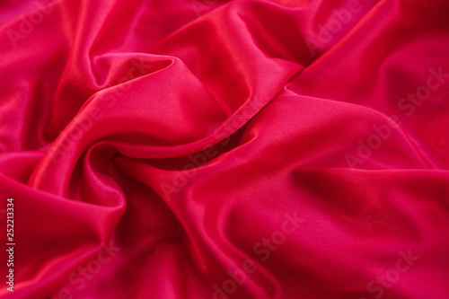 Close up red fabric. The purple fabric is laid out waves. Pink sateen fabric for background or texture.