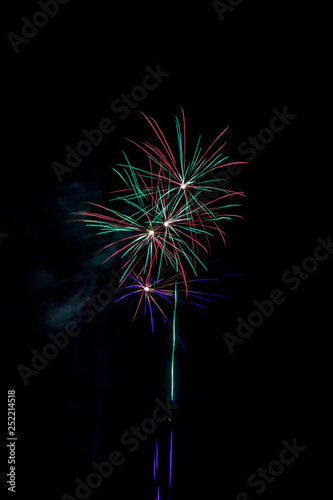 populous festive multi colour fireworks outside the city in the summer camp on isolated background of the night black sky