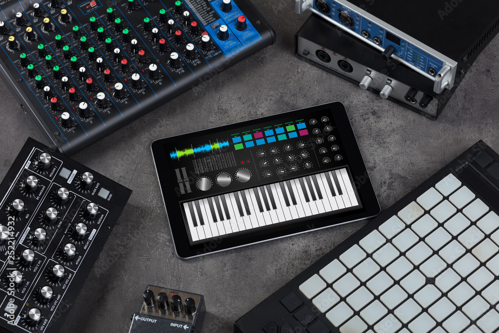 Piano synthesizer app on tablet and musical instrument concept
