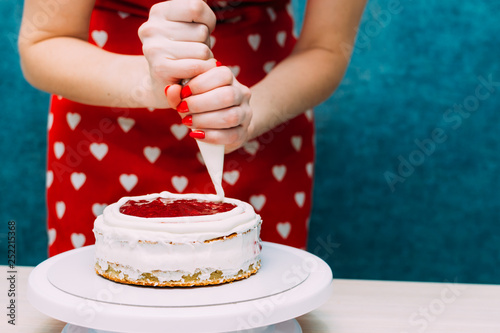Photography housewife applies the cream on the cake biscuit cake