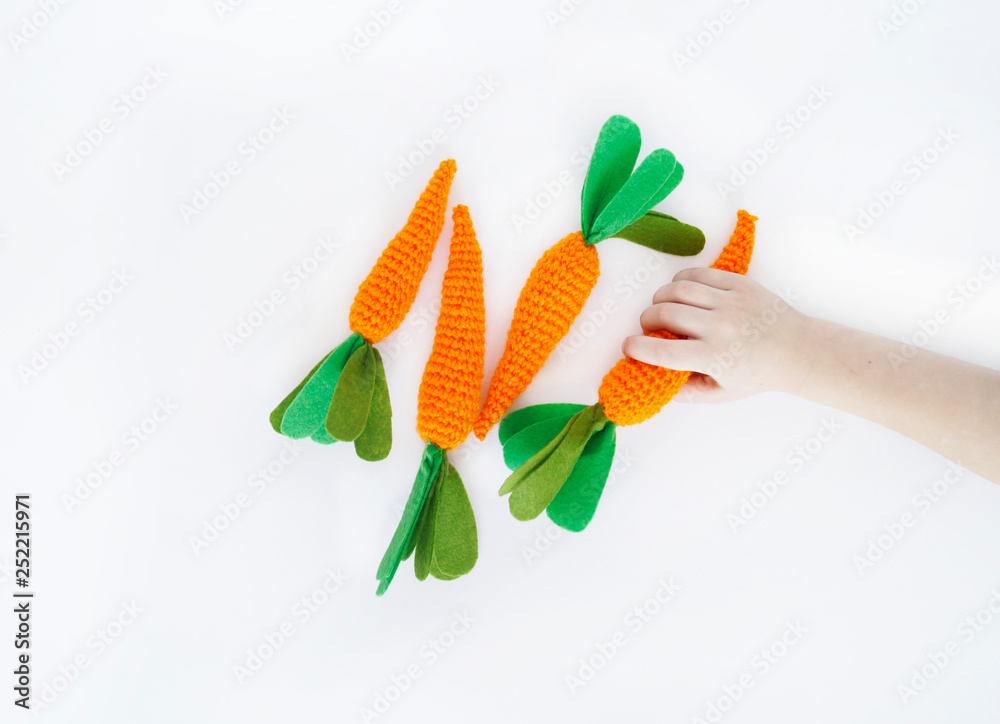 Fototapeta premium Easter. Knitted carrot toy. The process of creating the carrot.