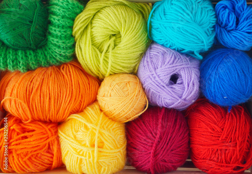 Colorful woolen balls of yarn are in the basket. Needlework. Knitting.