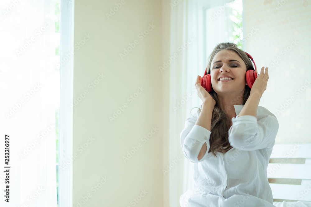 Lifestyle Beautiful cute girl woman feel happy enjoy listening to music with earphones headphones on white bedroom Lifestyle Beautiful cute girl woman feel happy enjoy listening to music with earphones headphones on white bedroom