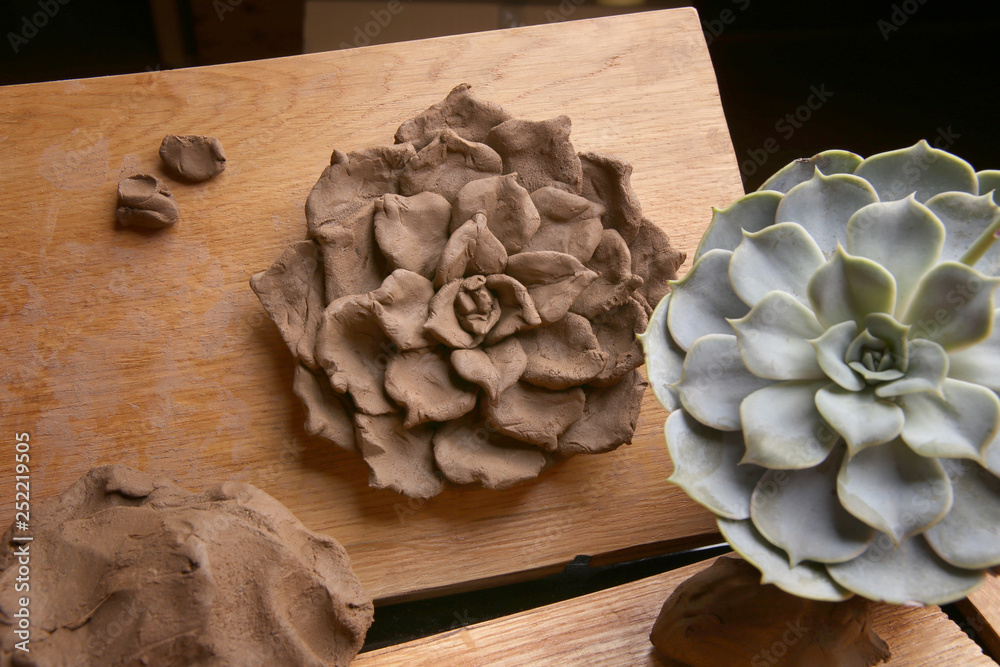 Sculpting clay plant decoration with model echeveria houseplant . Sculpting  clay crafts pottery in the process. Stock Photo