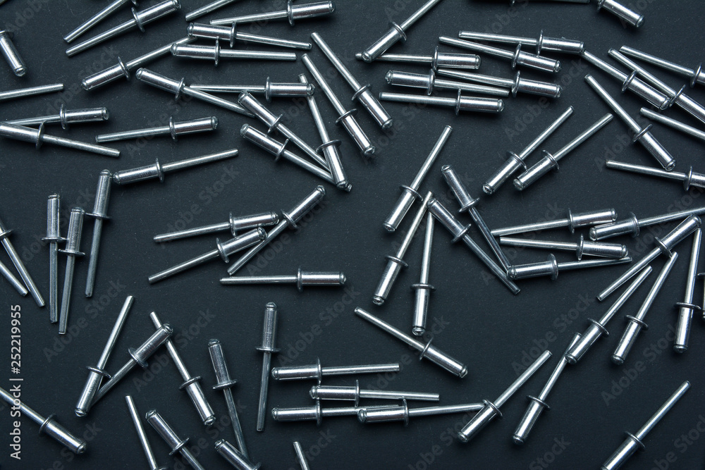 Metal rivet background. A lot ot rivets on black background. Top view. Flat lay. Metal rivet background. A lot ot rivets on black background. Top view. Flat lay.