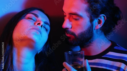 stoned,drunk lovers flirting in the darkness of night club