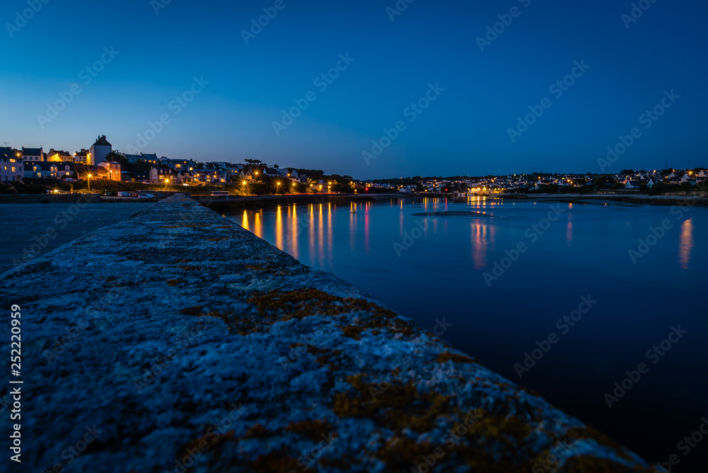 Obraz premium Audiernes town and harbour at night with lights on in Bretagne