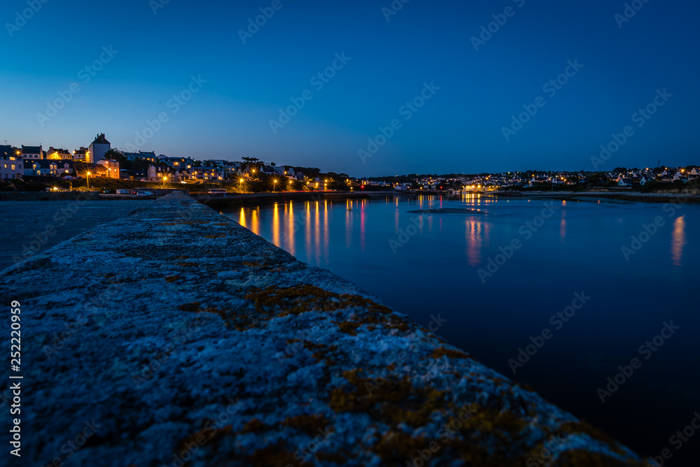 Audiernes town and harbour at night with lights on in Bretagne