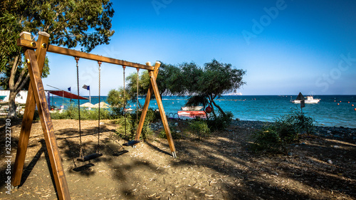 wooden swing on the Beautiful beach. Sunbeds with umbrella on the sandy beach near the sea. Summer holiday and vacation concept. Inspirational tropical beach