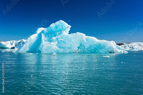 Blue iceberg in the water against the blue sky