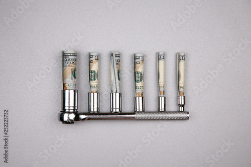 Concept of fixing currency of money and tools. Set of Wrenches and dollars on a gray background