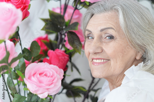 Portrait of senior woman portrait with blooming flowers