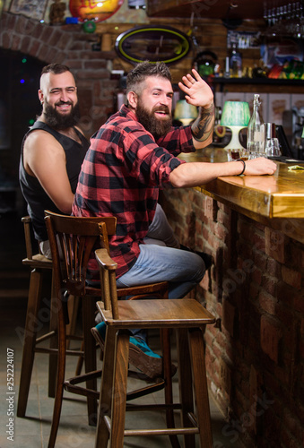 Friends relaxing in pub. Order drinks at bar counter. Hipster brutal bearded man spend leisure with friend at bar counter. Men relaxing at bar. Friday relaxation in bar. Friendship and leisure © be free