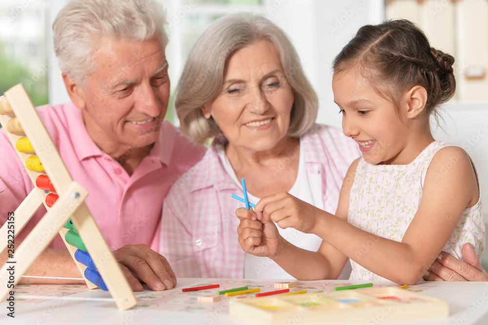 Portrait of happy grandparents with granddaughter using abacus together Portrait of happy grandparents with granddaughter using abacus together