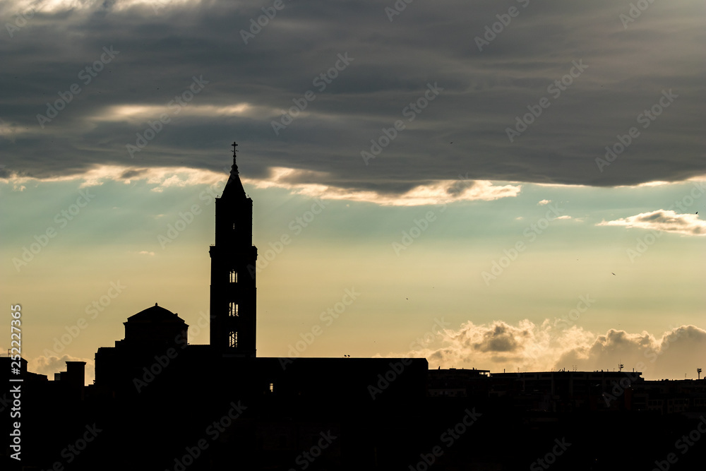 Amazing sky and church silhouette view of ancient town of Matera, the Sassi di Matera, Basilicata, Southern Italy, cloudy summer afternoon just before sunset Amazing sky and church silhouette view of ancient town of Matera, the Sassi di Matera, Basilicata, Southern Italy, cloudy summer afternoon just before sunset