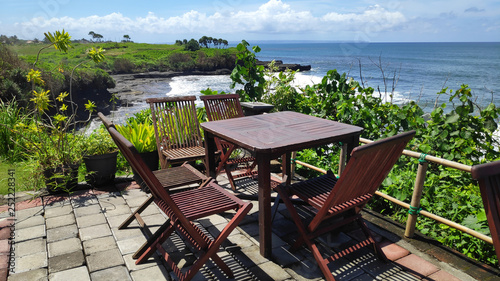 Table and chair with view of cliff and ocean near Tanah Lot, Bali