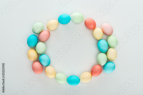 top view of colorful easter eggs as frame isolated on grey