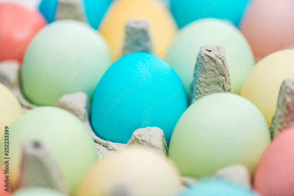 close up of pastel easter eggs in paper containers, selective focus
