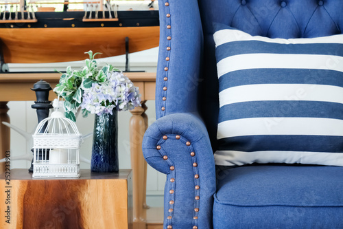 Home interior decoration with american Newport style, living room have a blue sofa and wooden table with flower and cage.