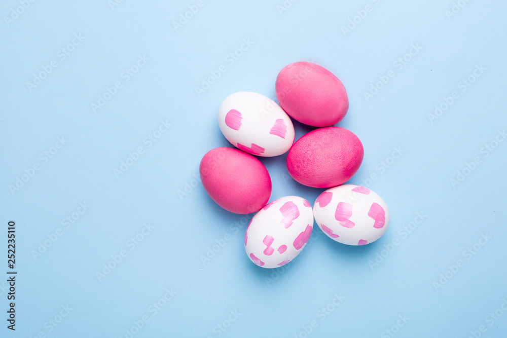 Easter pink eggs with watercolor brushstrokes on a blue background