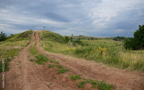 Summer landscape with unpaved roads among high green hills