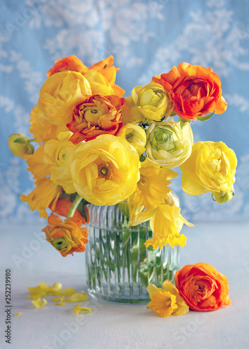Spring bouquet of a yellow flowers on a blue light background.