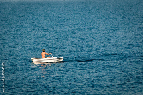 Man rowing a boat in the early morning, Makarska, Croatia