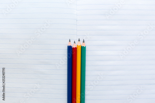  Multicolored pencils on notebook in a ruler