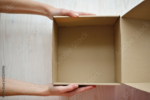 Woman hands hold an empty (blank) gift box (container, case) for holiday, christmas, thanks giving day, birthday top view. © galina_d