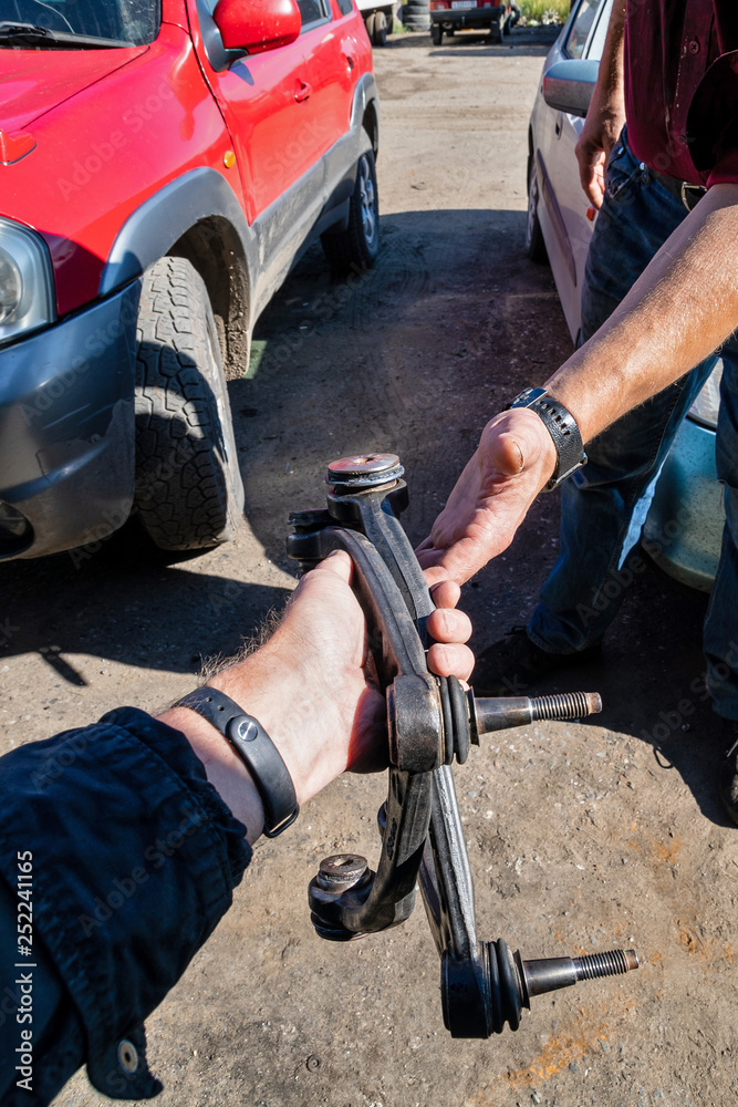 Obraz premium Car workshop - client gives the car parts of automobile from mechanic