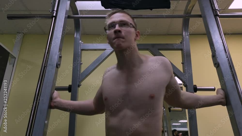 Sporty man stretching arm before gym workout. Fitness strong male athlete standing indoor warming up Sporty man stretching arm before gym workout. Fitness strong male athlete standing indoor warming up