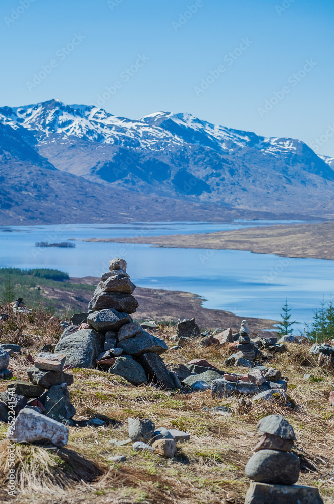 Highlands view of mountains and river with a stack of stones on foreground