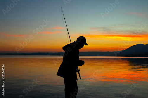 illustration of man fishing at sunset