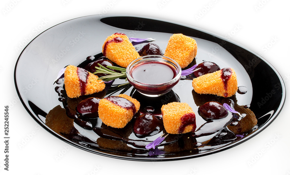 Fried Camembert with cranberry sauce on a glossy black plate Fried Camembert with cranberry sauce on a glossy black plate