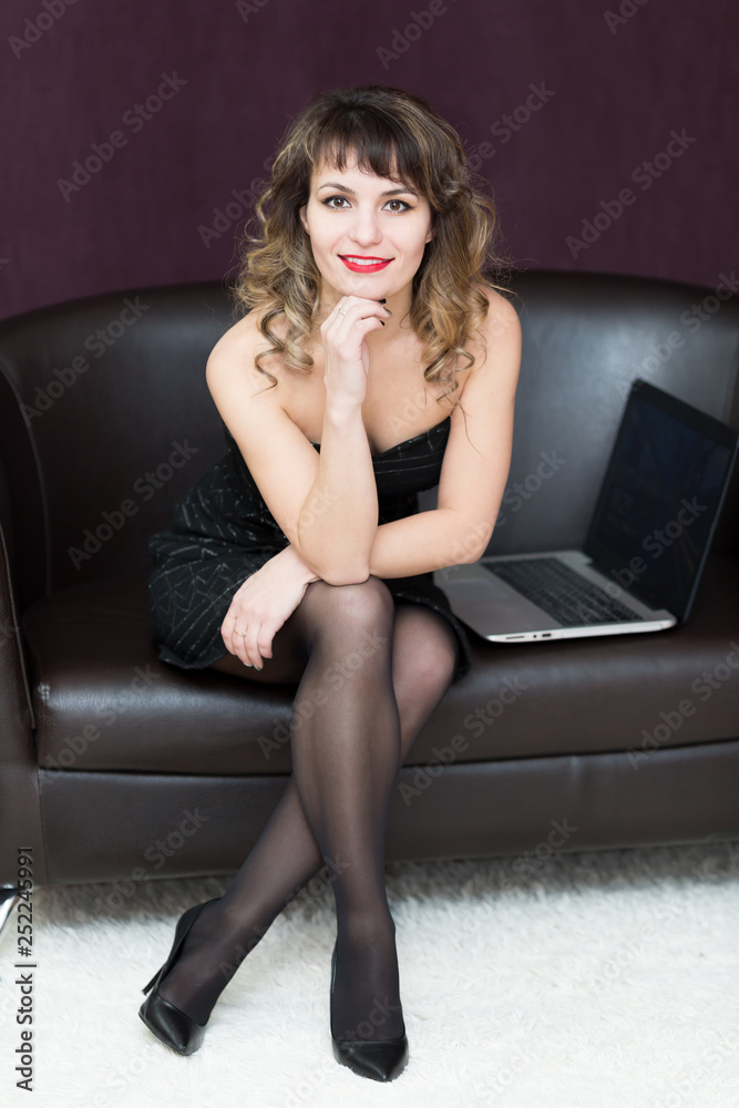 A girl of 30 years old sitting on a black sofa. A girl of 30 years old sitting on a black sofa.