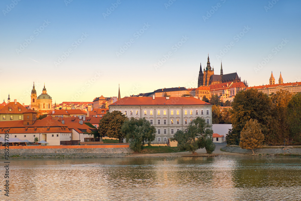 ltava riverside on sunrise, with St. Vitus cathedral and castle forming skyline behind