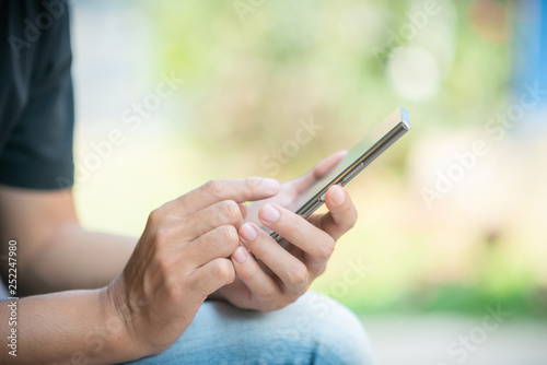 Close up of man typing text message on smartphone or hands using mobile phone.